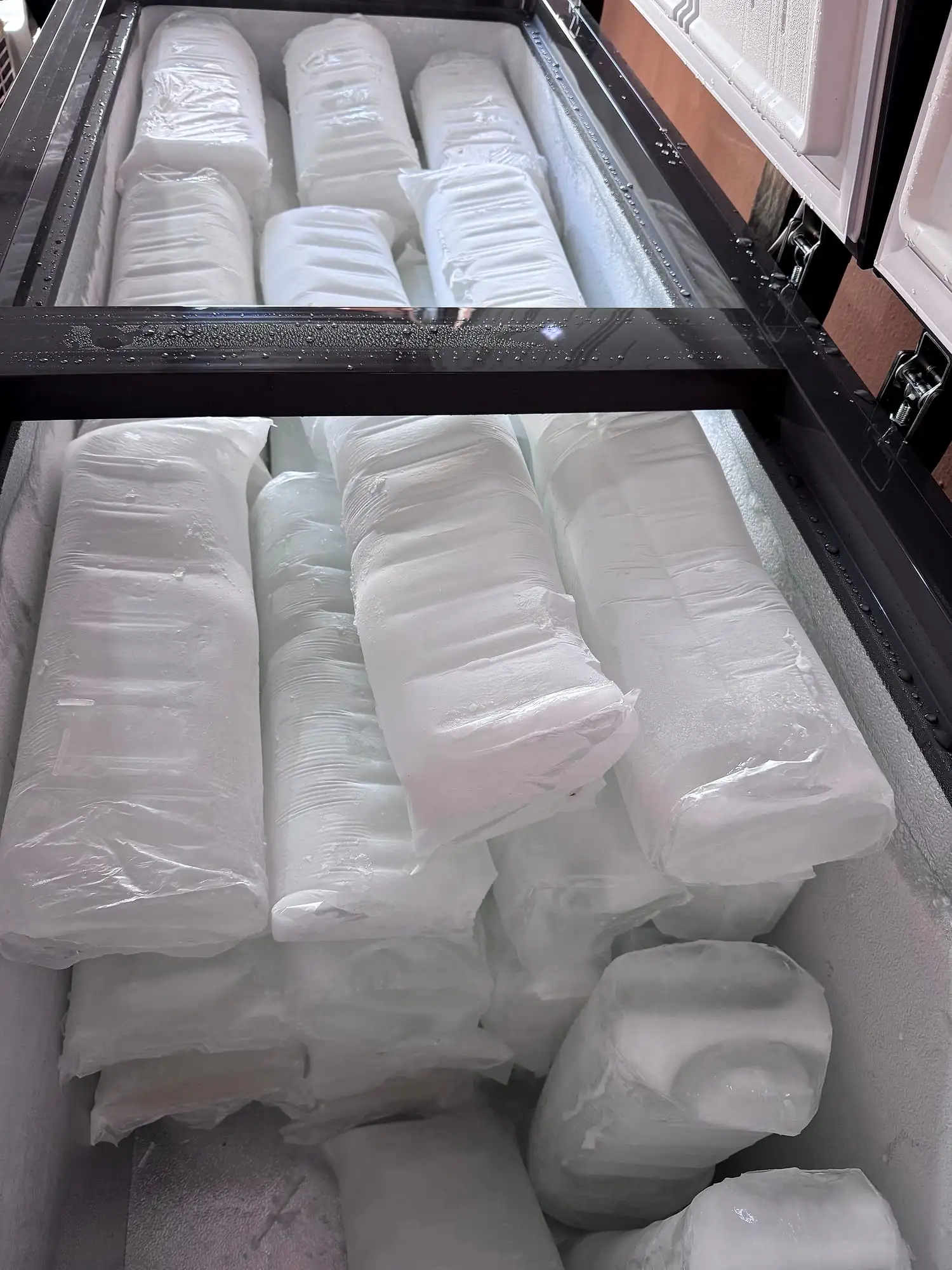 Wrapped Boss Ice blocks stacked in a chest freezer.